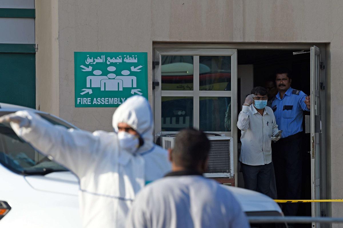 رجال شرطة بحرينيون يغلقون مبنى بعد أن ثبتت إصابة مريض بالفيروس التاجي