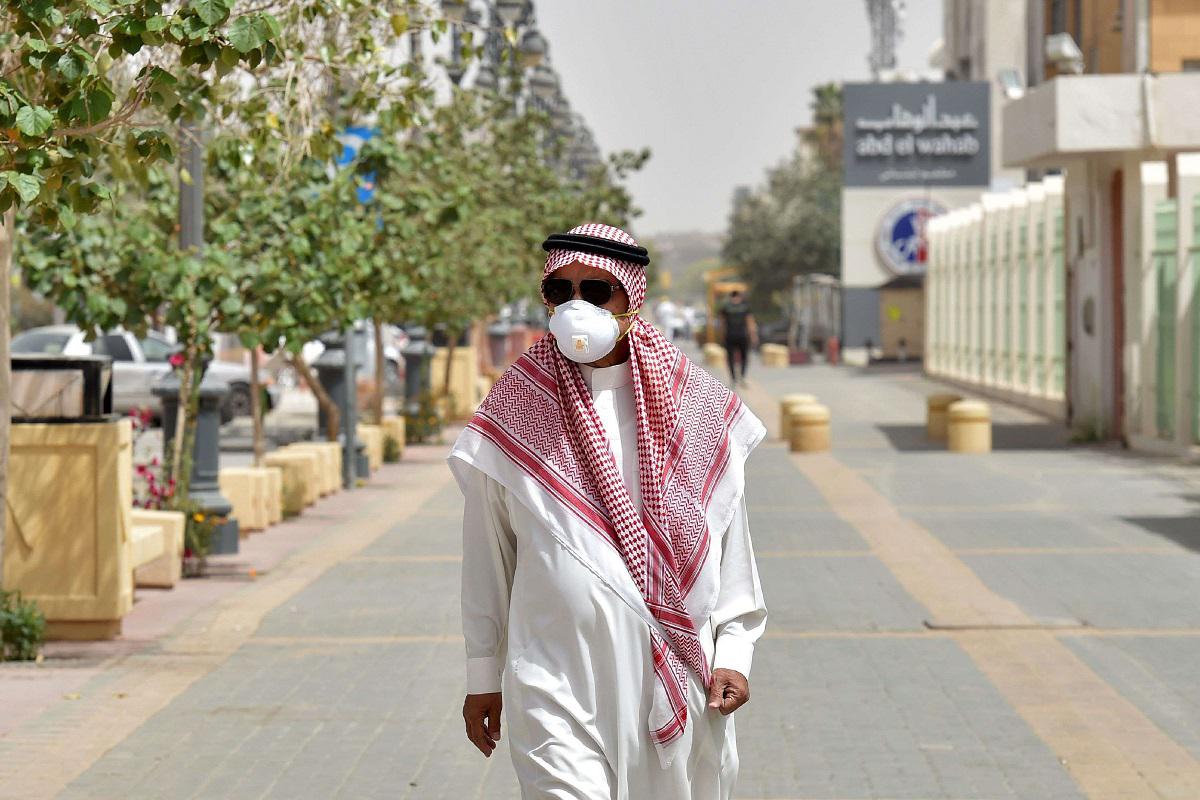 سعودي يضع كمامة للوقاية من فيروس كورونا يمشي في أحد شوارع الرياض
