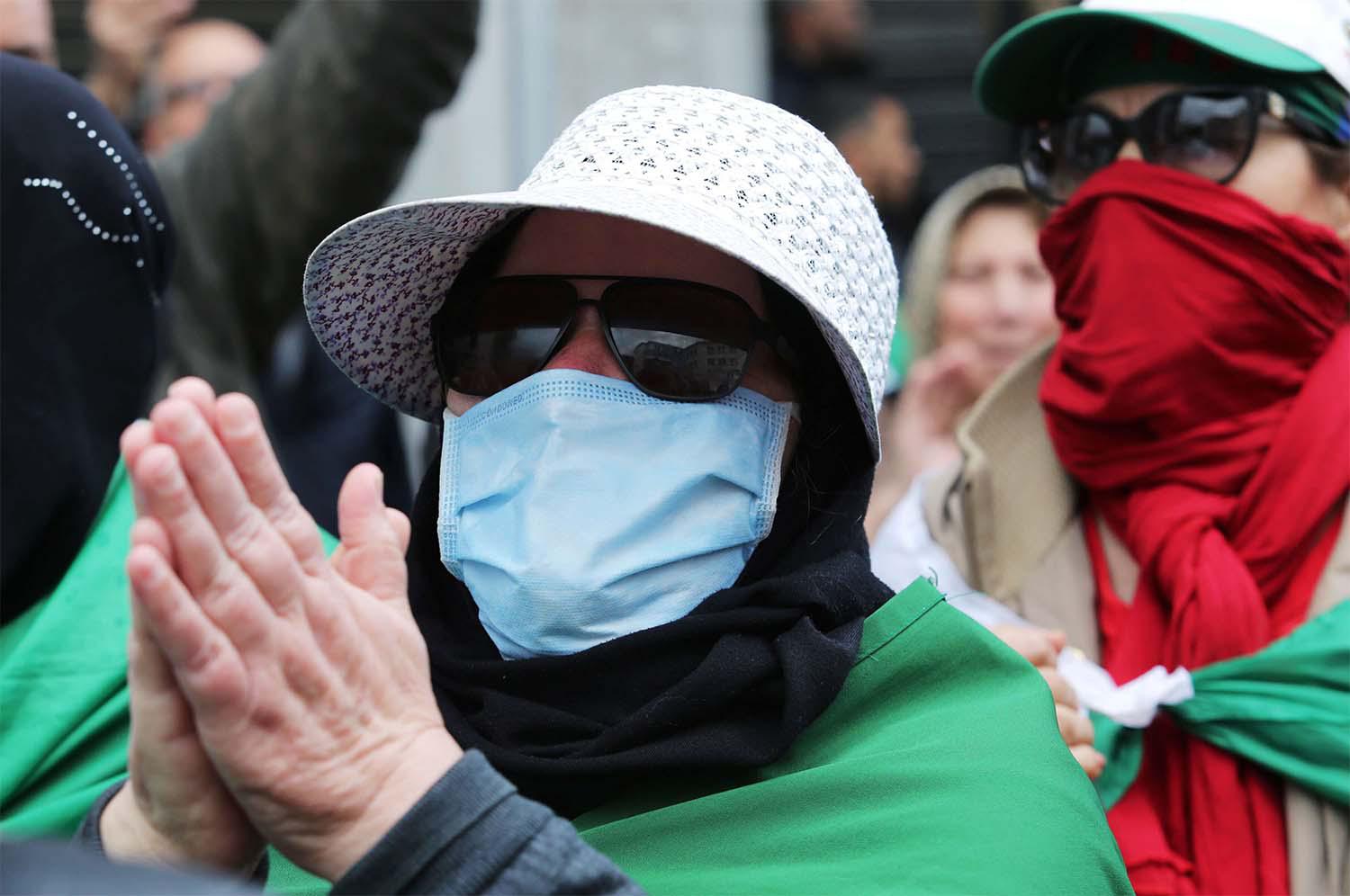 Algerian woman wearing a face mask gestures during an anti-government protest