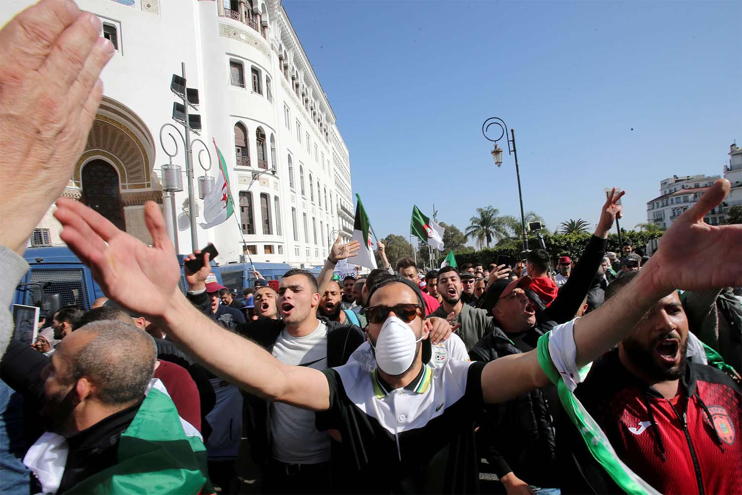 A demonstrator wearing a face mask gestures during an anti-government protest in Algiers, February 28