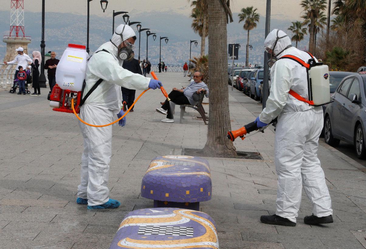 Employees from a disinfection company sanitize a bench as a precaution against the spread of the coronavirus, at Beirut's seaside Corniche