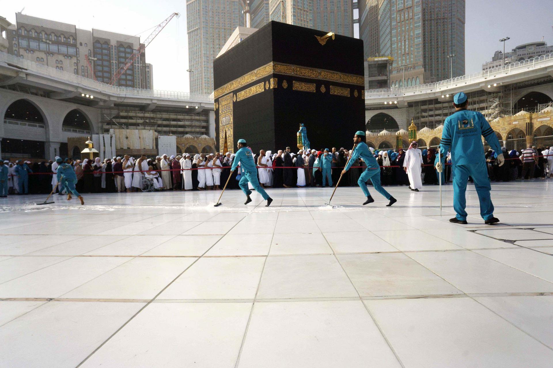 Workers sterilize the ground in front of the Kaaba