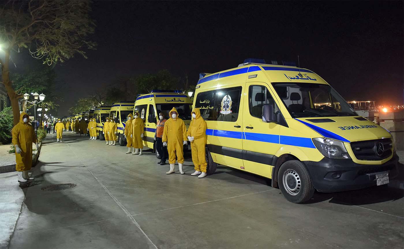 Egyptian health ministry emergency responders stand next to ambulances