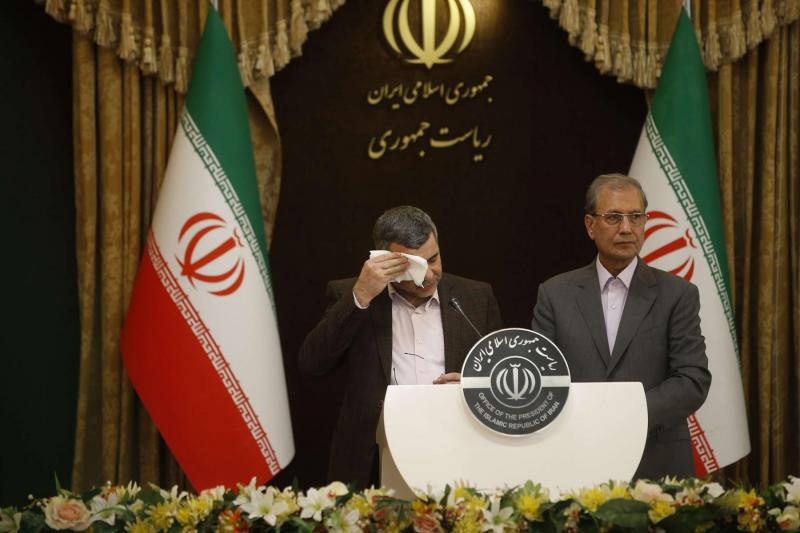  Iranian Deputy Health Minister Iraj Harirchi (L) wipes the sweat off his face during a news conference with government’s spokesman Ali Rabiei in Tehran