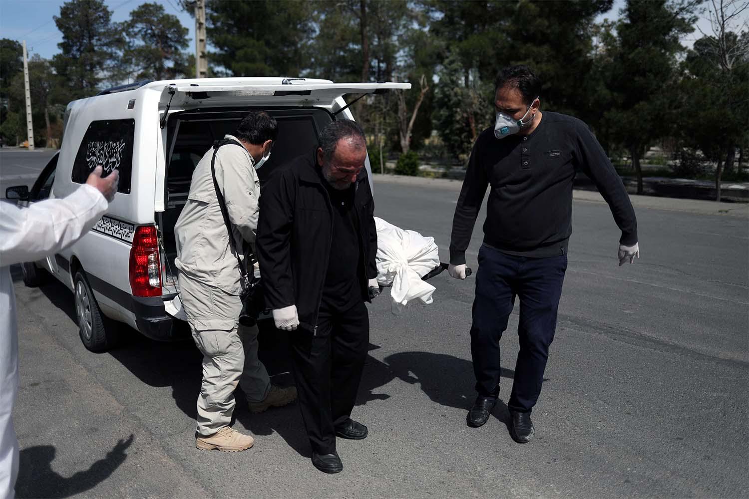 Iranian men carry the coffin of the journalist Abdollah Zavieh, who passed away due to coronavirus disease