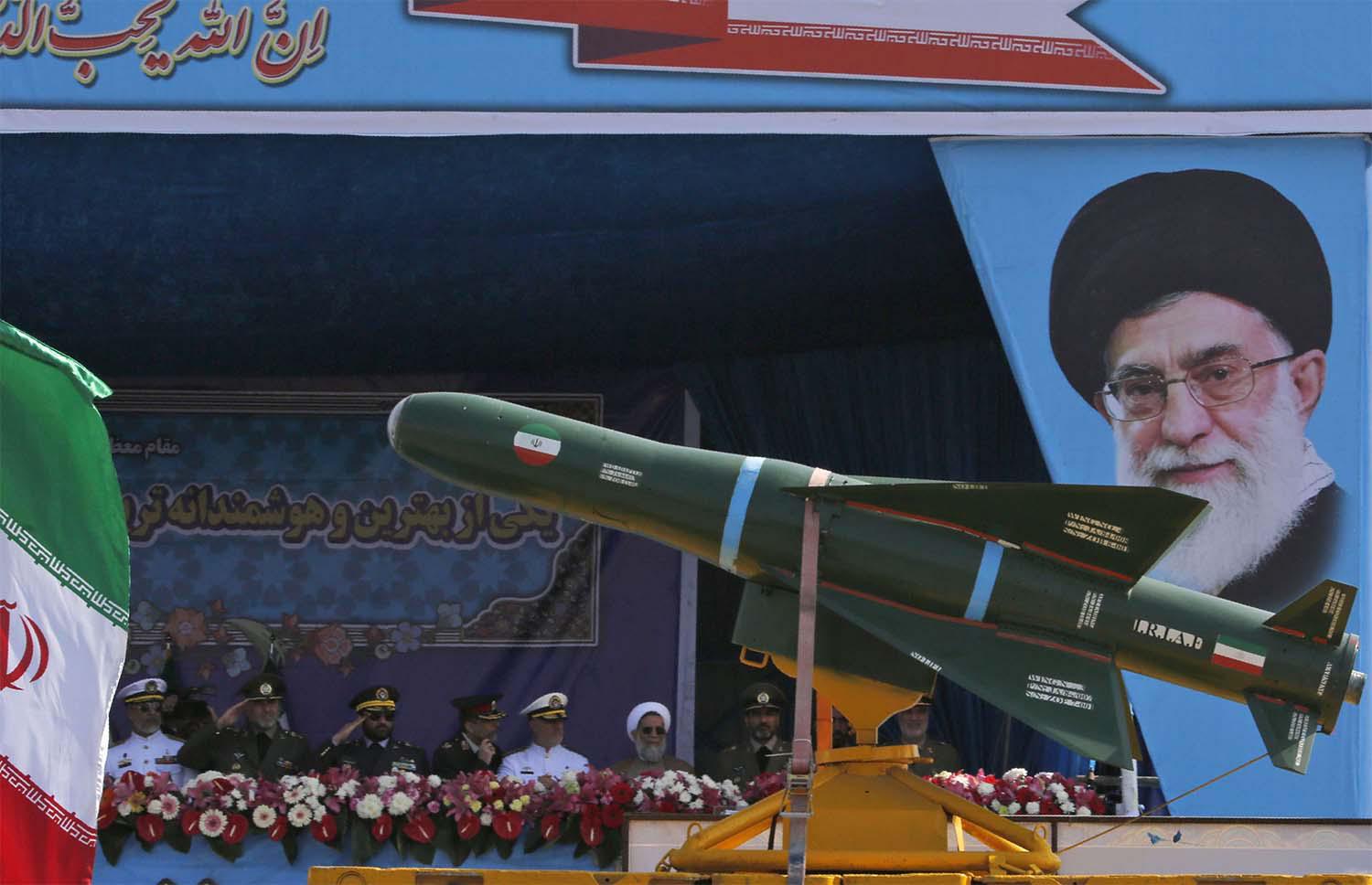 An Iranian military truck carries missiles past a portrait of Iran's Supreme Leader Ayatollah Ali Khamenei during a military parade