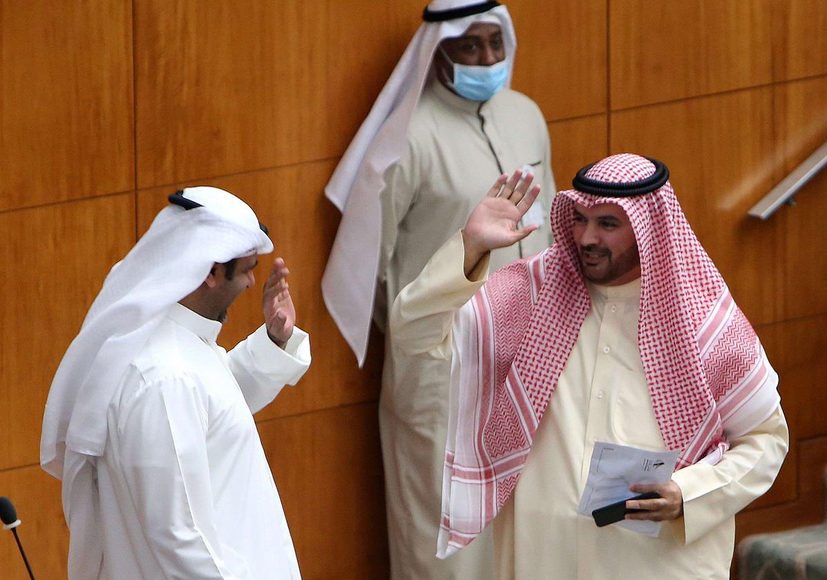 النائبان الكويتيان حمدان العازمي وراكان النصف يحييان بعضهما برفع أيديهما خلال جلسة برلمانية