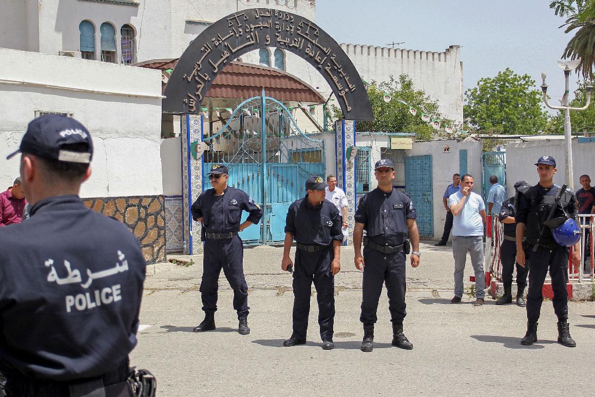 Algerian policemen stand guard outside the El Harrach prison in Algiers