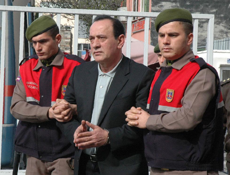 April 11, 2008 file photo, paramilitary police offices escort Alaattin Cakici before a trial in Istanbul.