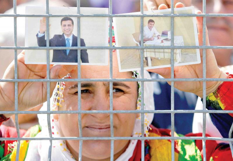 A woman holds pictures of jailed former leader of Turkey’s main pro-Kurdish Peoples’ Democratic Party Selahattin Demirtas