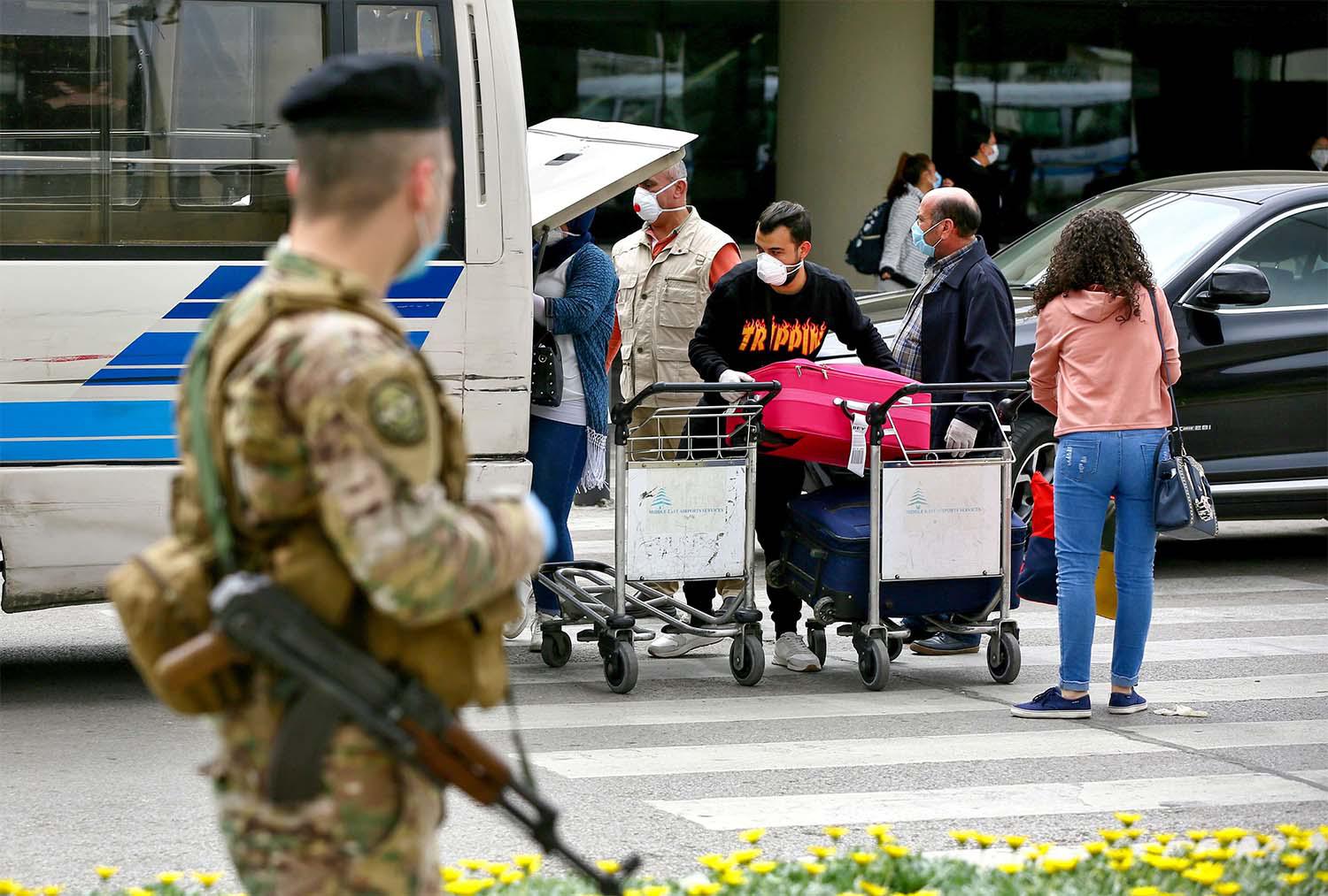 Passengers putting their luggage in a bus upon their arrival at Beirut airport from Saudi Arabia