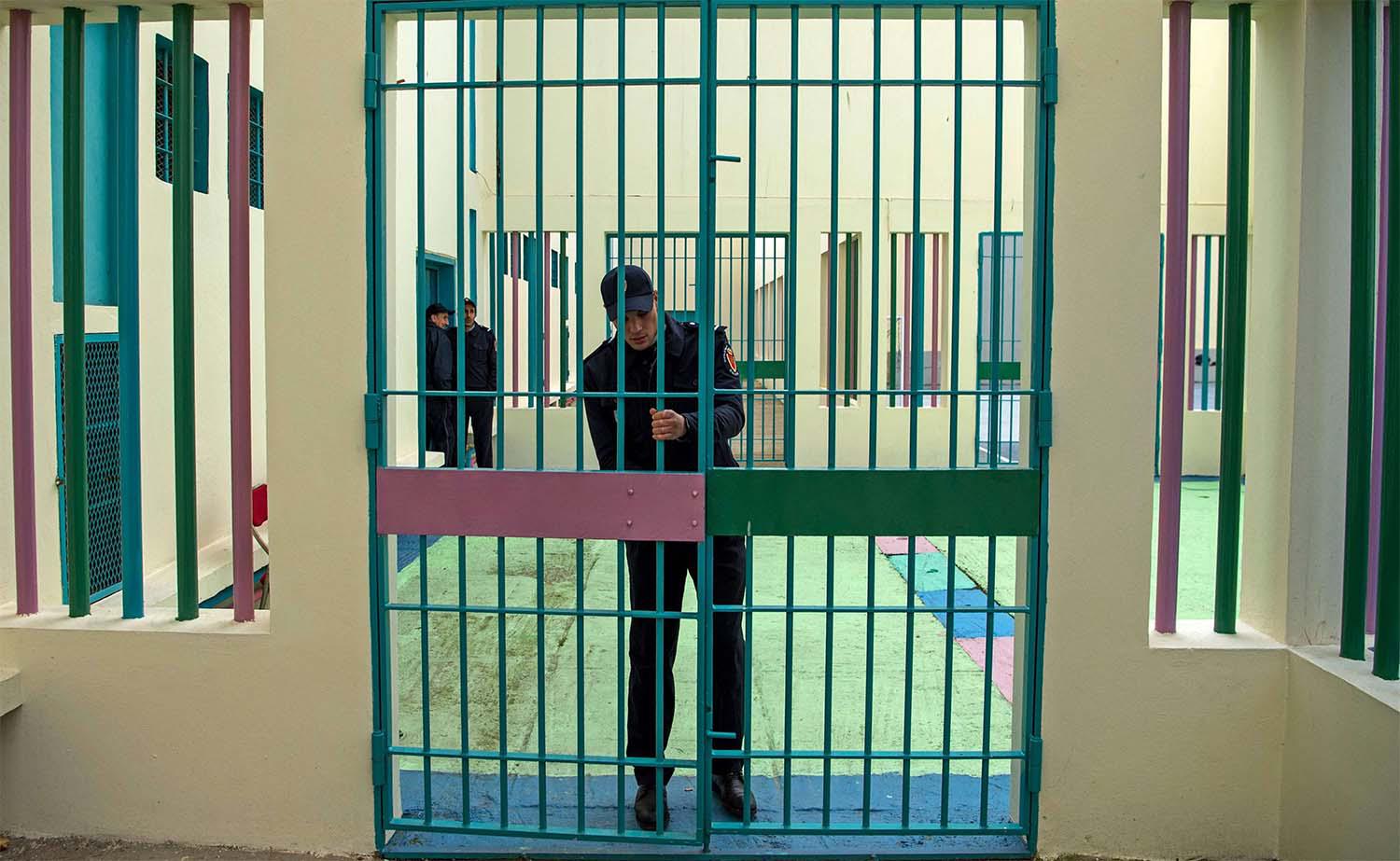 A prison warden locks a gate at the Oukacha prison in Casablanca