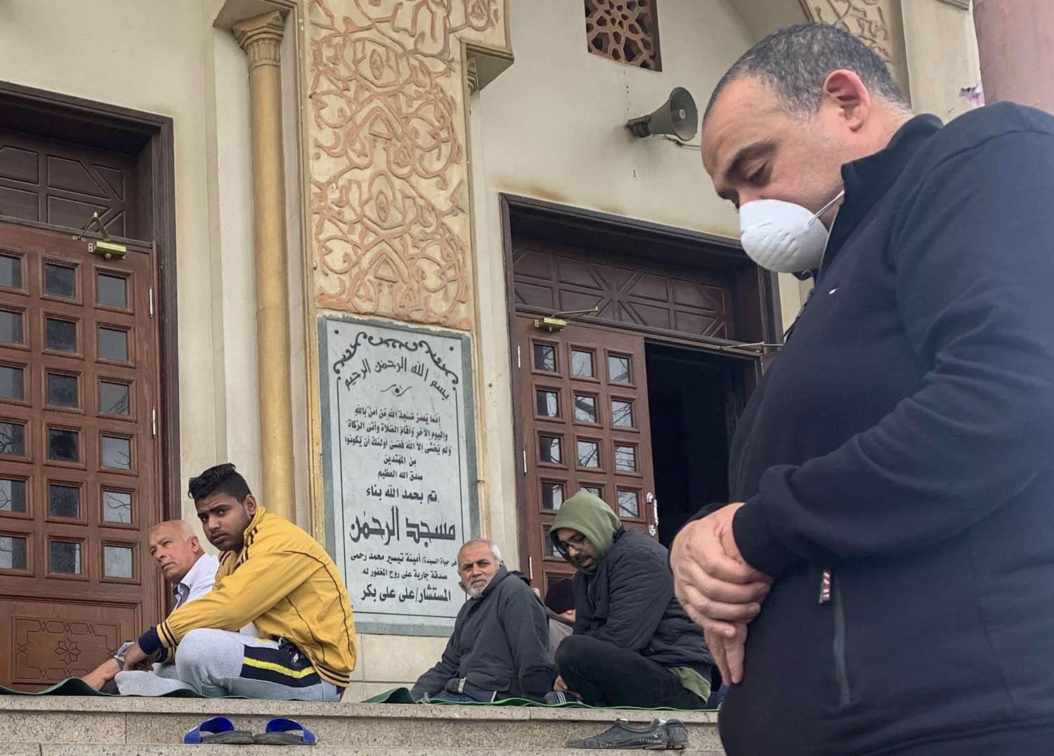 مصريون يصلون على باب جامع بعد منع الصلاة في الجوامع بسبب كورونا