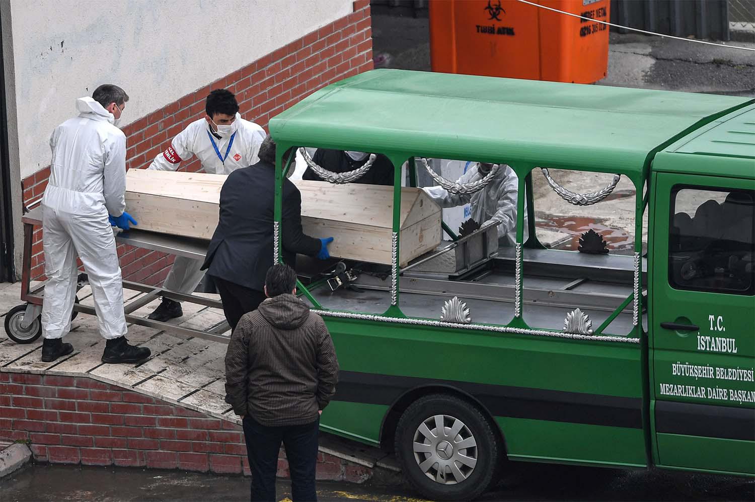 Officials put a coffin inside a funeral vehicle in an Istanbul morgue