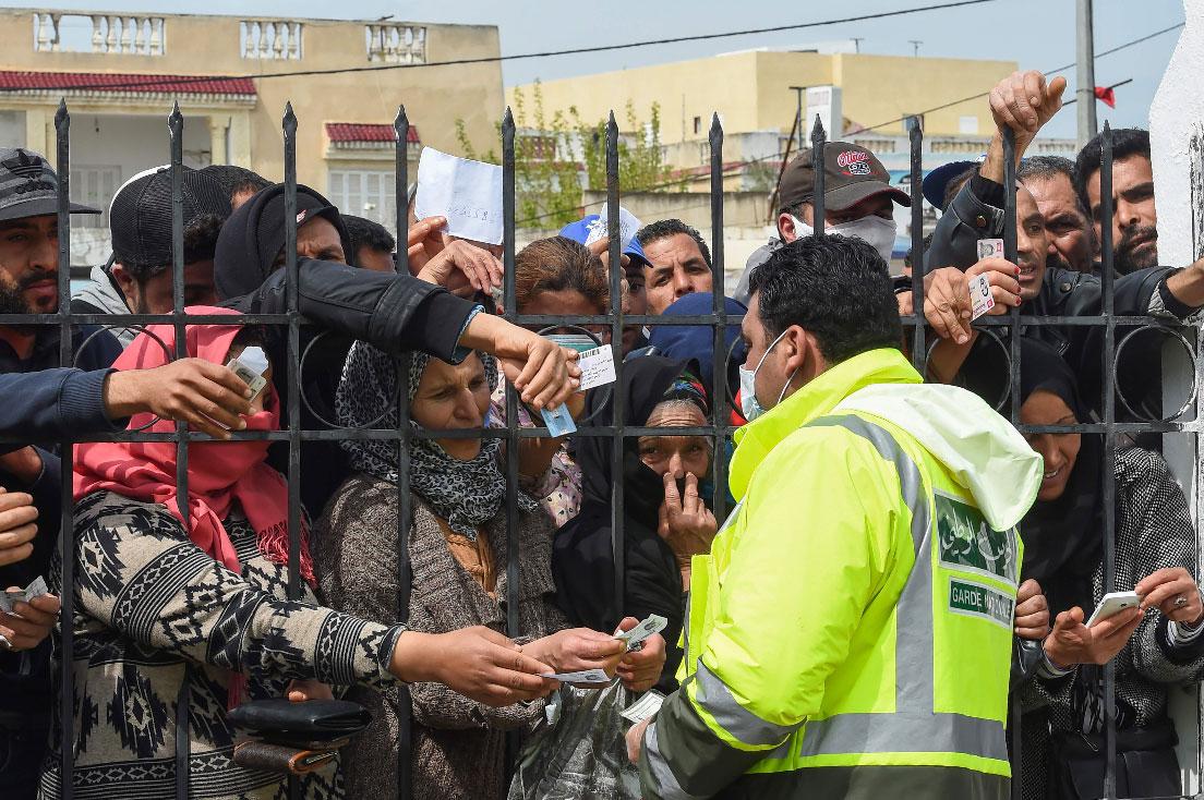 Impoverished Tunisian citizens gather with their identification cards in front of the headquarters of Mnihla delegation, in Ariana Governorate outside Tunis