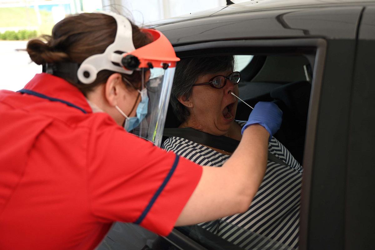 بريطانية من مدينة كامبردج تخضع في سيارتها لأخذ مسحة من الأنف لفحص فيروس كورونا