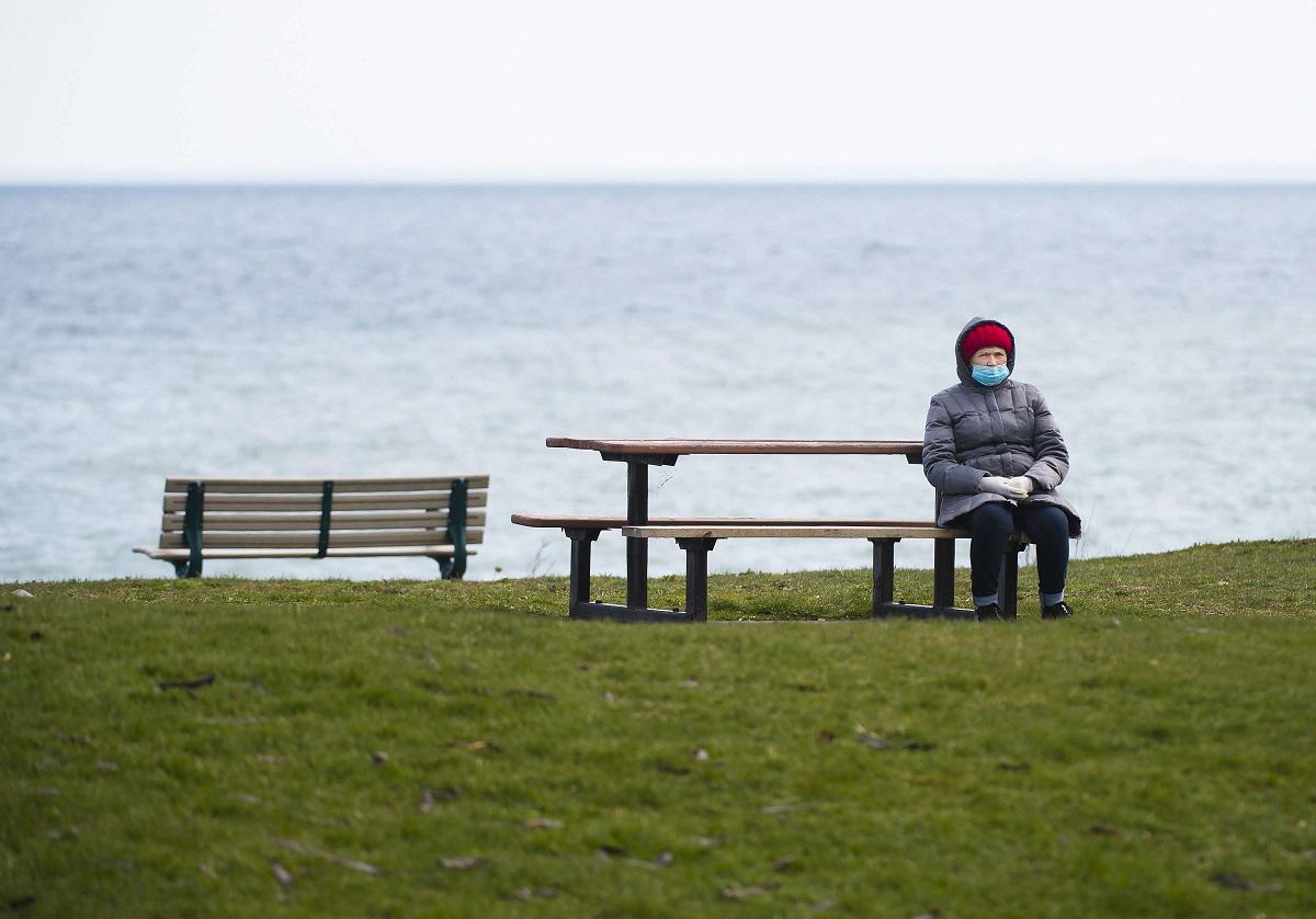 امرأة مسنة تجلس بمفردها على بحيرة أونتاريو في تورنتو بكندا