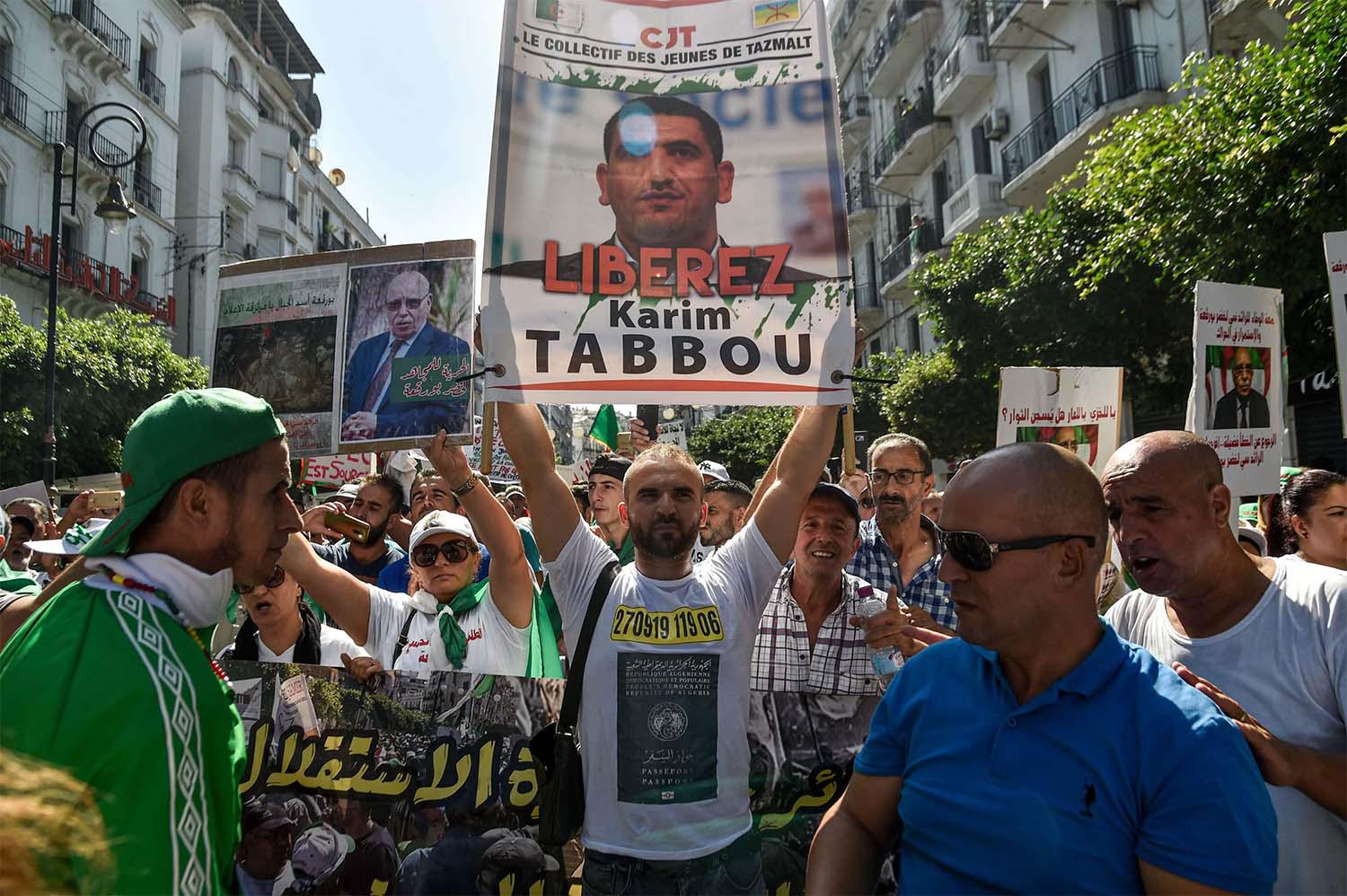 Algerian protester marches with a sign calling to set free politician Karim Tabbou during a protest last September