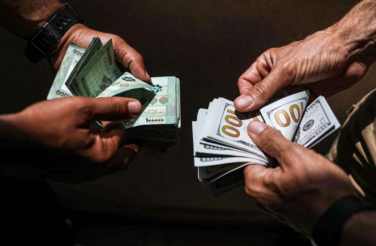 لبنانيان يصرفان دولارات مقابل الليرة