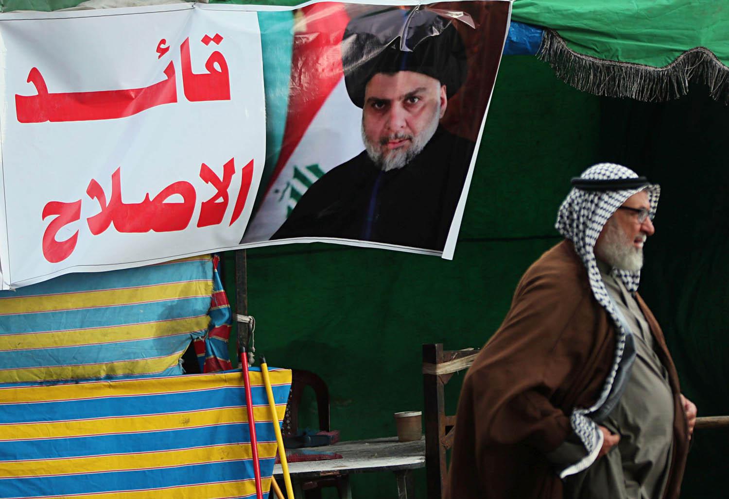 عراقي يمر بجانب ملصق يمجد مقتدى الصدر