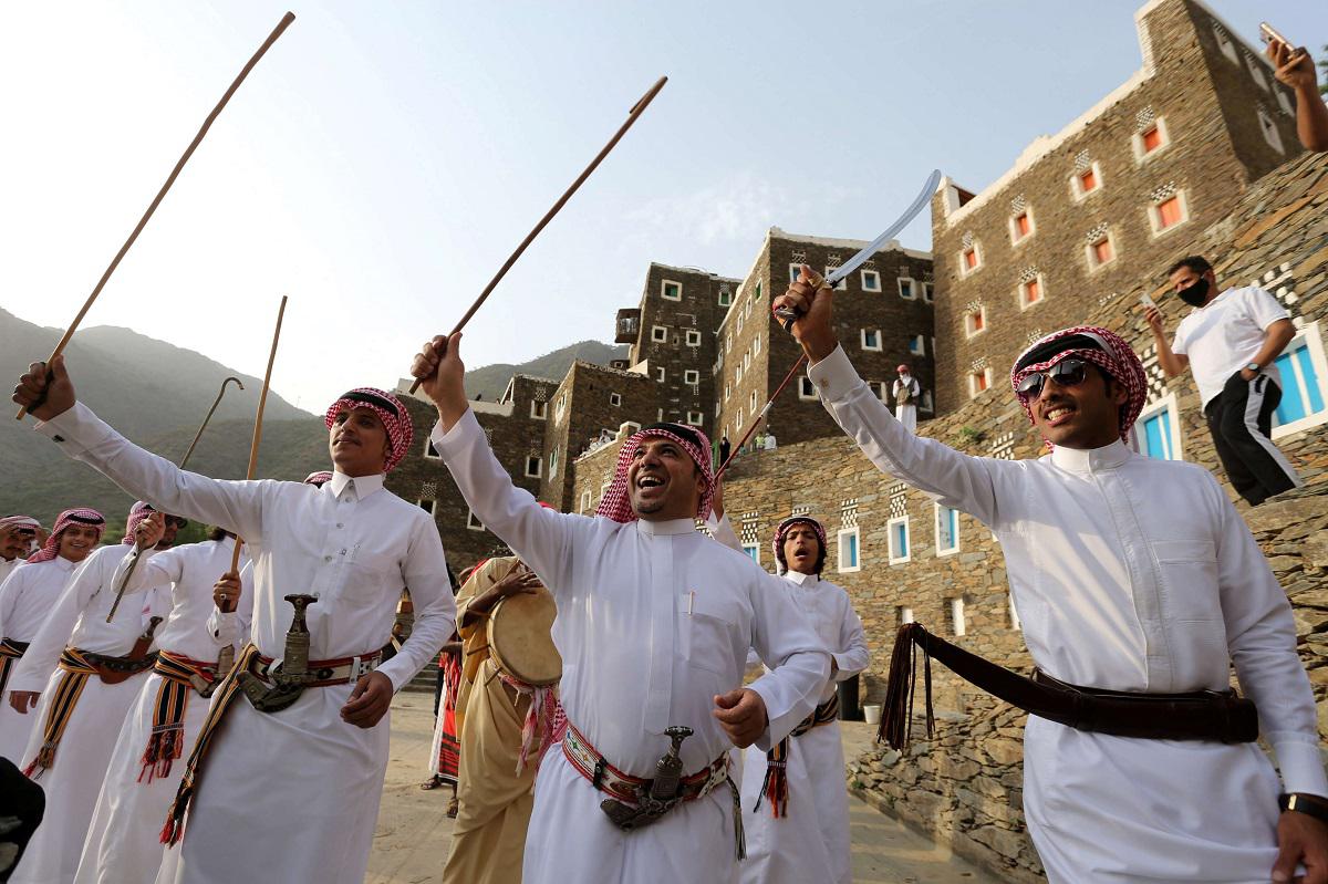  سعوديون يؤدون رقصة شعبية تقليدية في قرية رجال ألمع الثقافية في السعودية