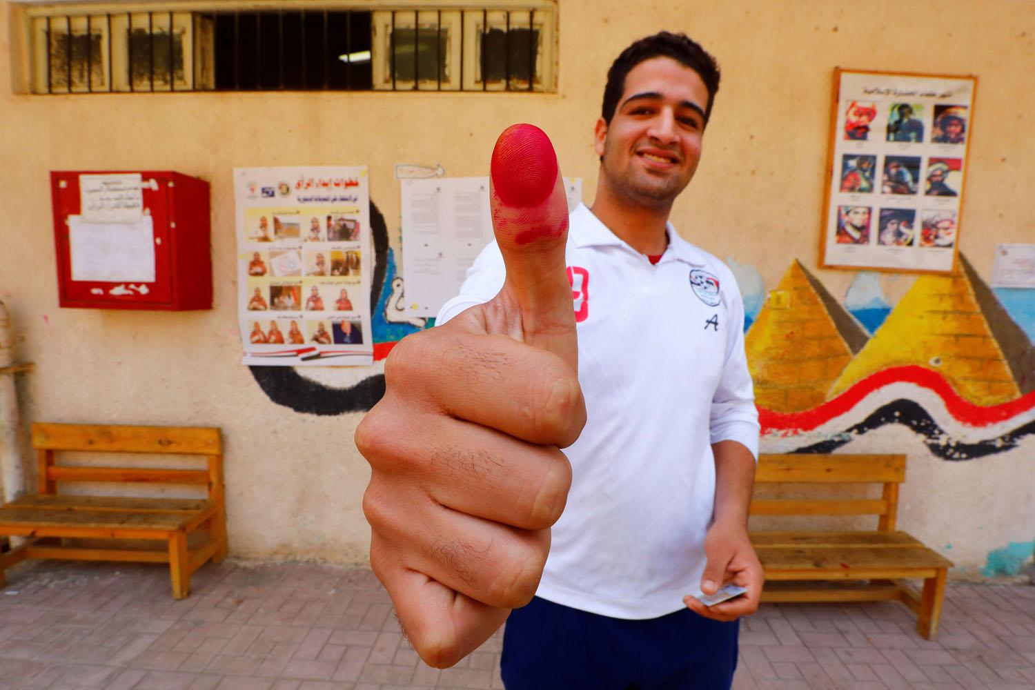 مصري يشير إلى مشاركته بالانتخابات