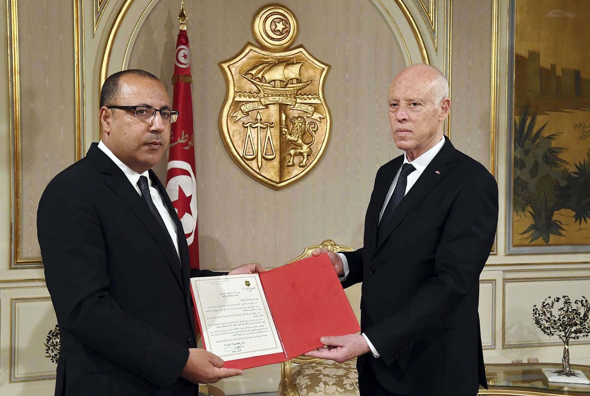 Tunisian president Kais Saied (R) appoints Interior Minister Hichem Mechichi as the country's new prime minister
