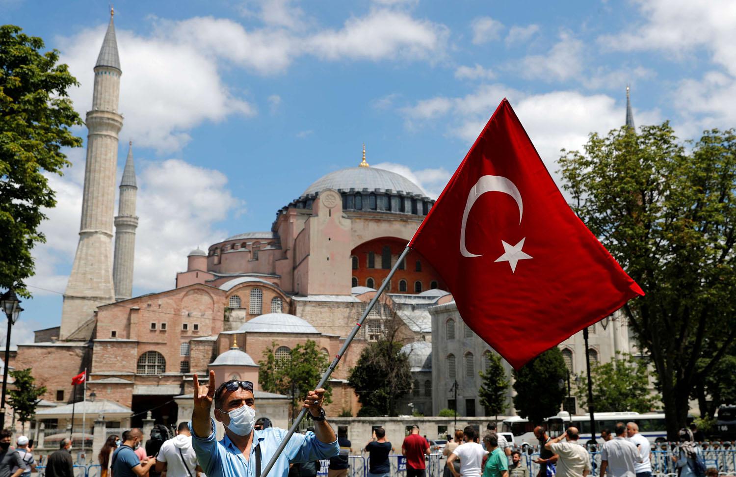 ناشط قومي يرفع علامة الذئب الرمادي وعلم تركيا أمام آيا صوفيا في اسطنبول