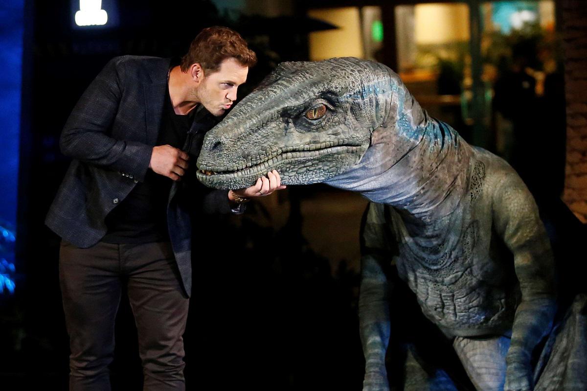 الممثل كريس برات يقبل مجسما لإحدى شخصيات الفيلم من الديناصورات