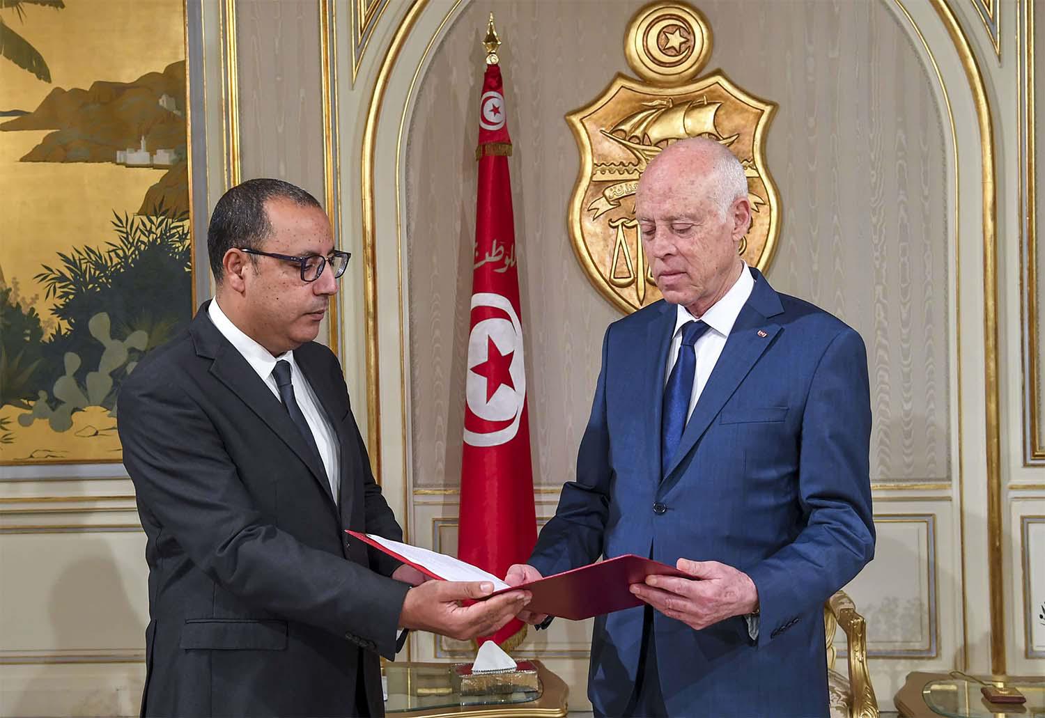 Tunisia's Prime Minister-designate Hichem Mechichi (L) presenting his cabinet list for Tunisian President Kais Saied (R) in Carthage palace