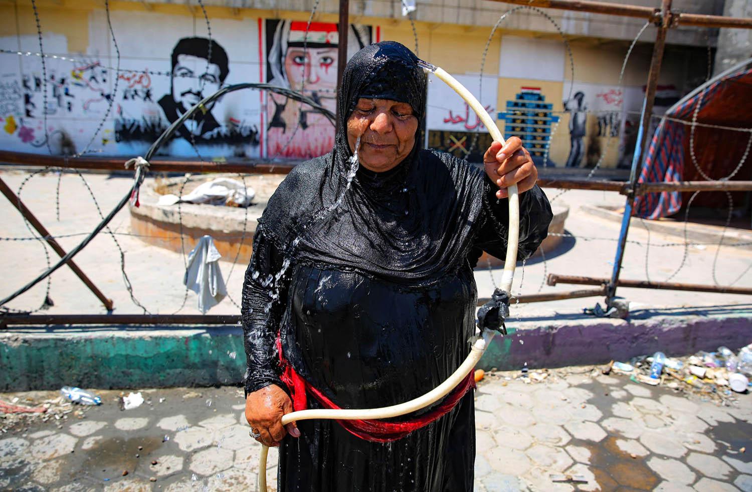 عراقية ترش نفسها بالماء في ساحة التحرير ببغداد