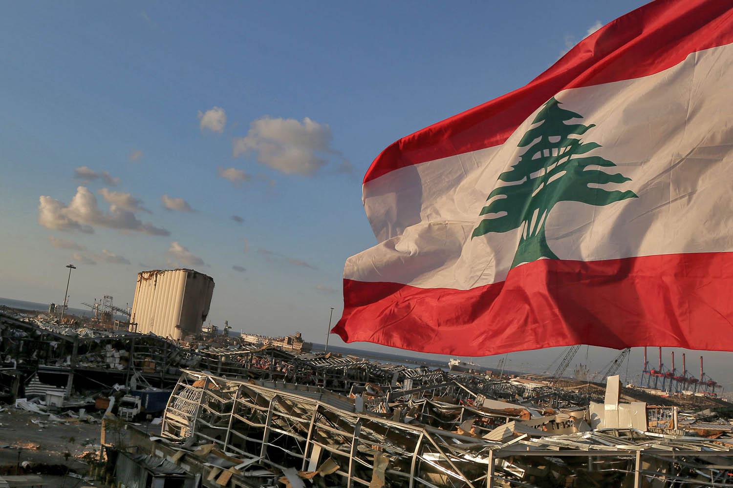 علم لبناني يرفرف على اطلال ميناء بيروت
