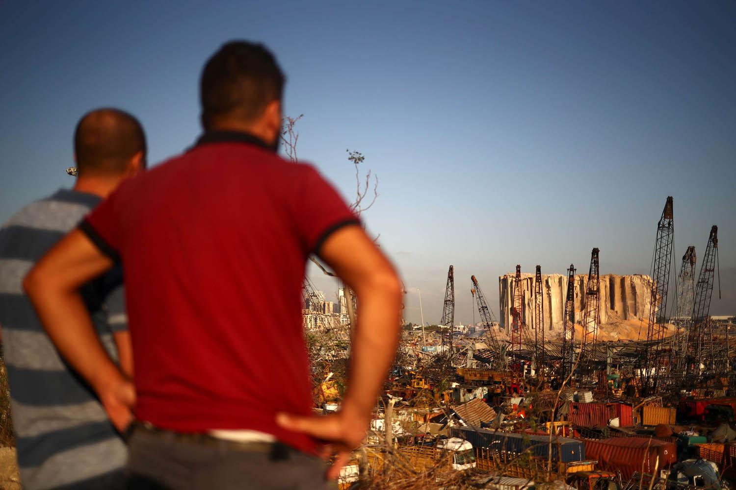 لبنانيون ينظرون على الدمار الذي اصاب مرفأ بيروت