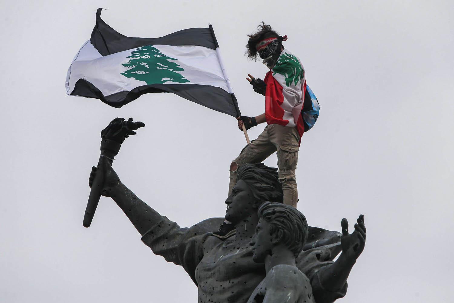 محتج لبناني يعتلي تمثال الشهداء وسط بيروت