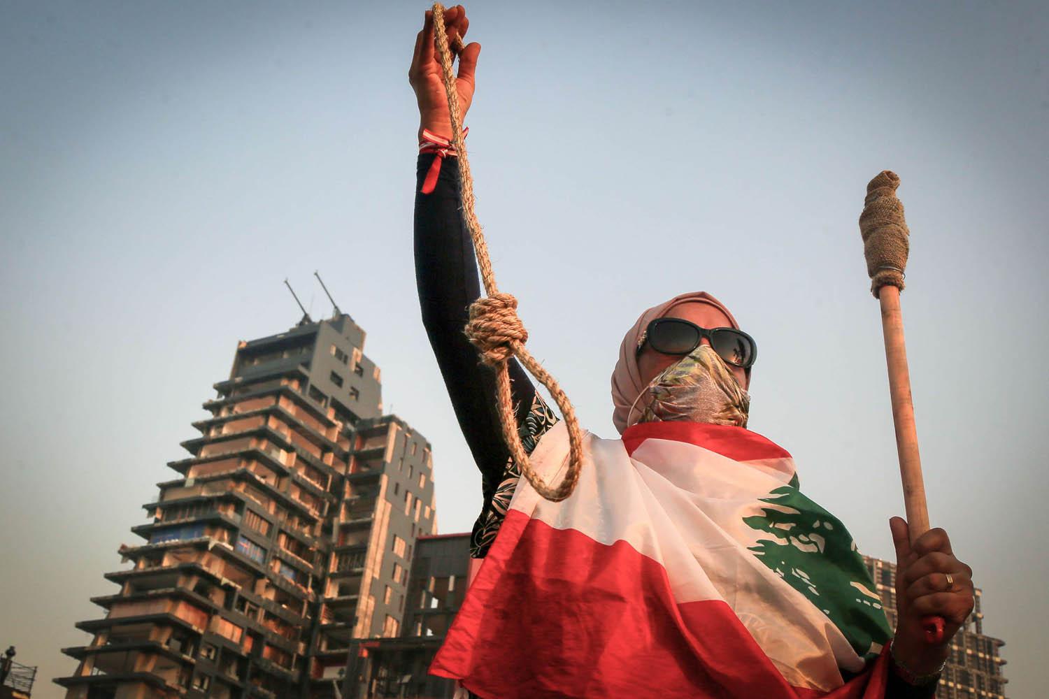 محتجة لبنانية تلوح بحبل في ذكرى شهر على انفجار بيروت