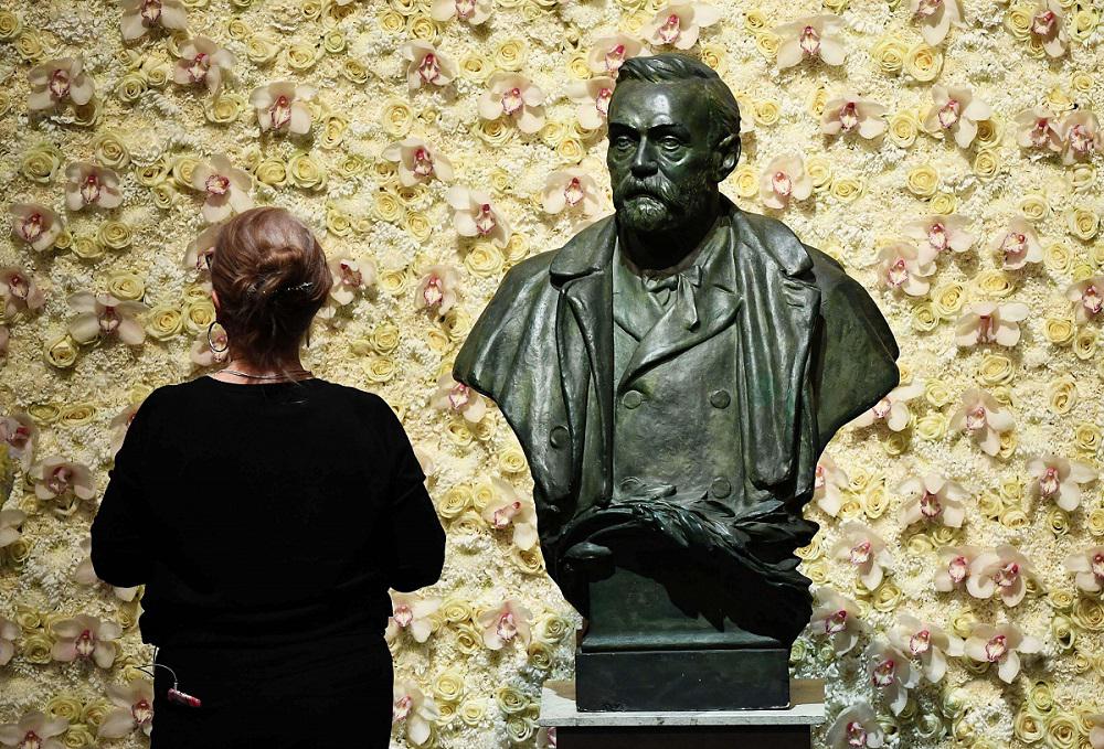 زائرة أمام تمثال نصفي لمؤسس جائزة نوبل ألفريد نوبل