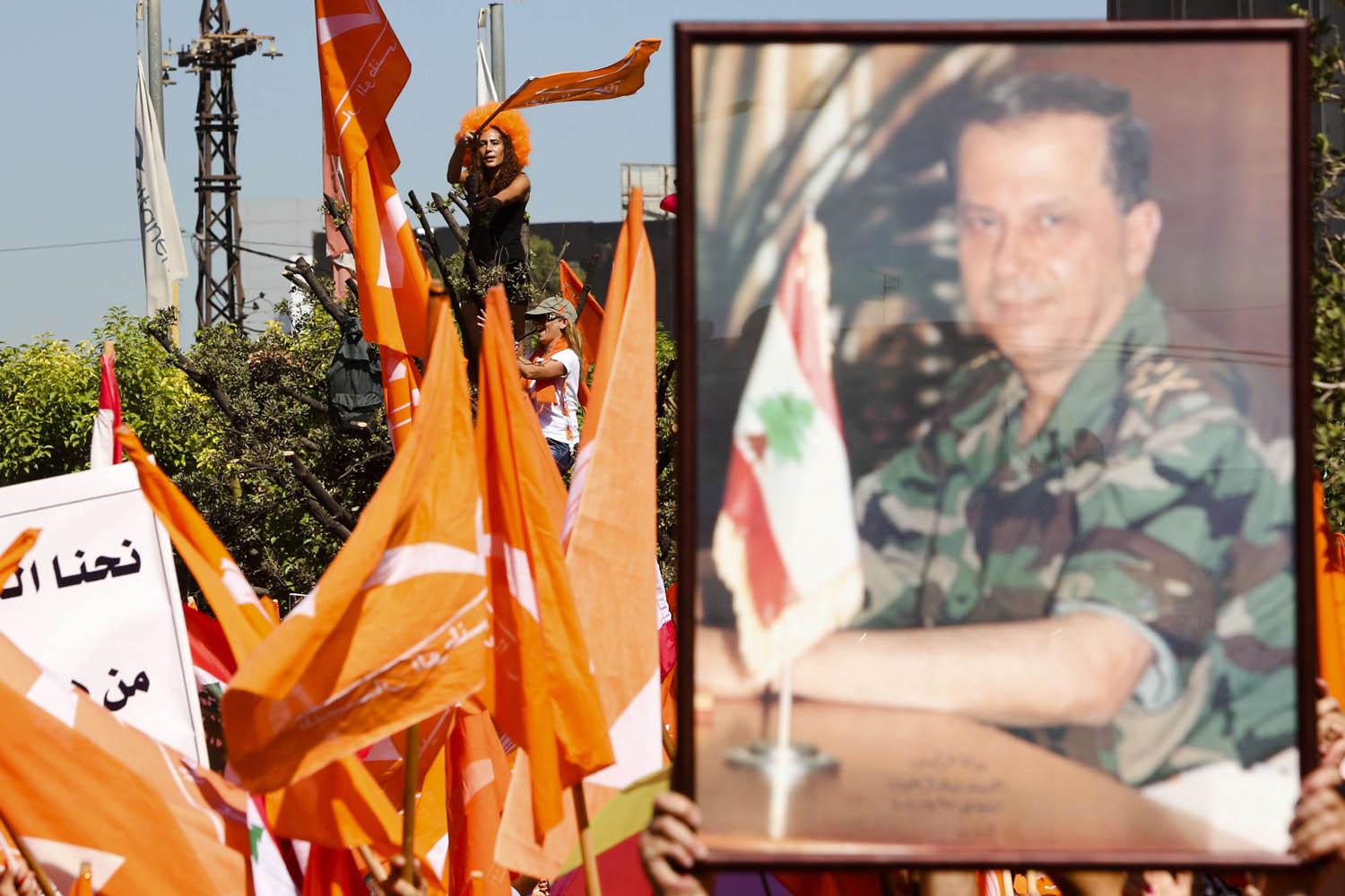 مؤيدون للتيار الوطني الحر يلوحون بصور قديمة للرئيس اللبناني ميشال عون