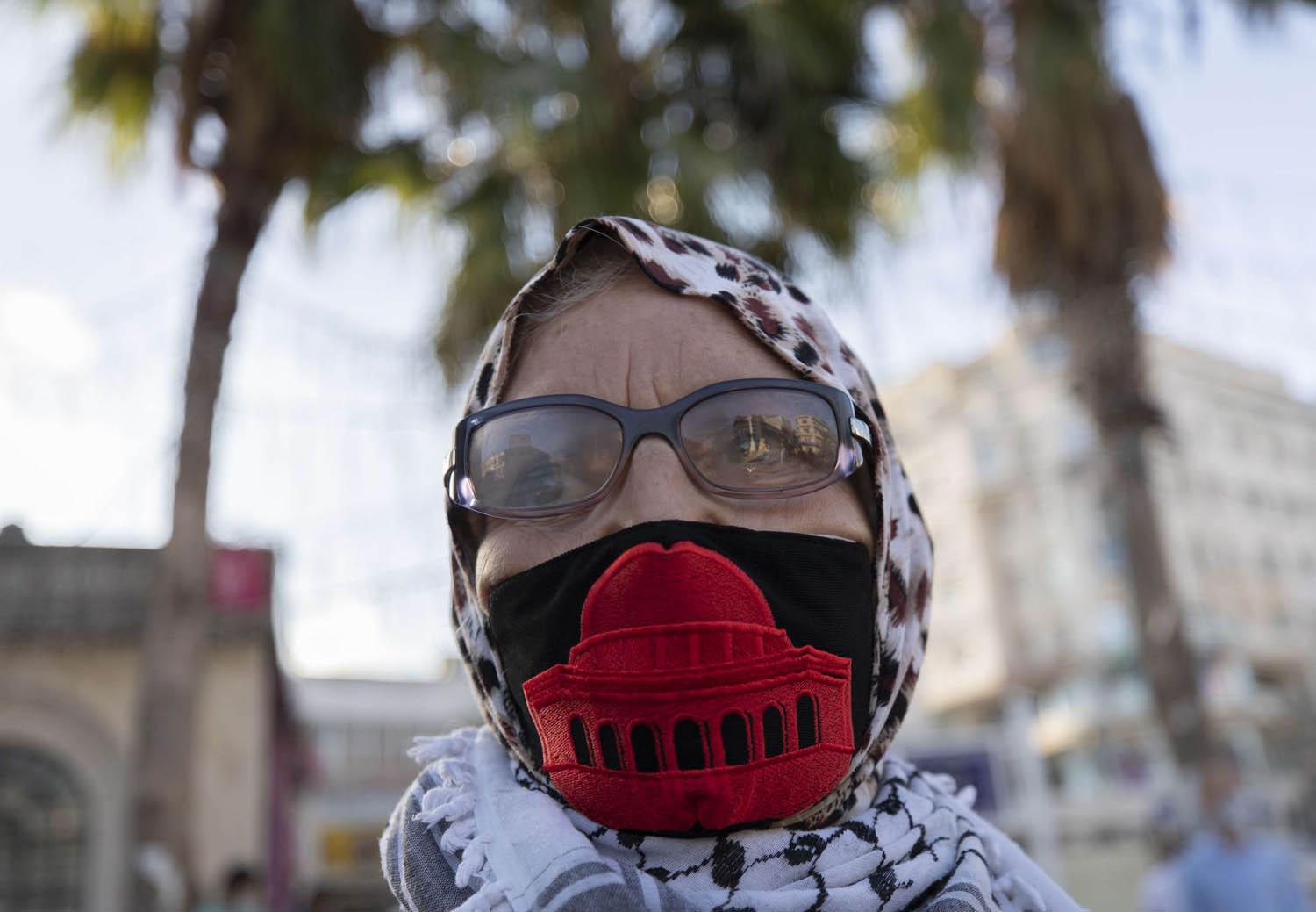 فلسطينية ترتدي كمامة عليها صورة القدس في مساندة للأسرى الفلسطينيين