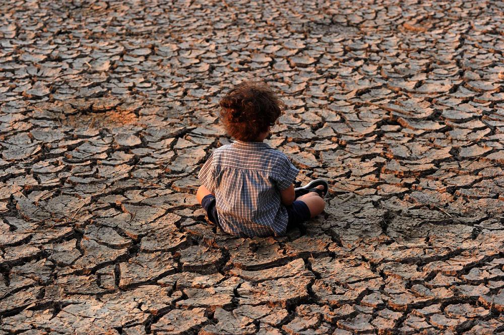 طفل في هندوراس يجلس في منطقة تضررت من الجفاف