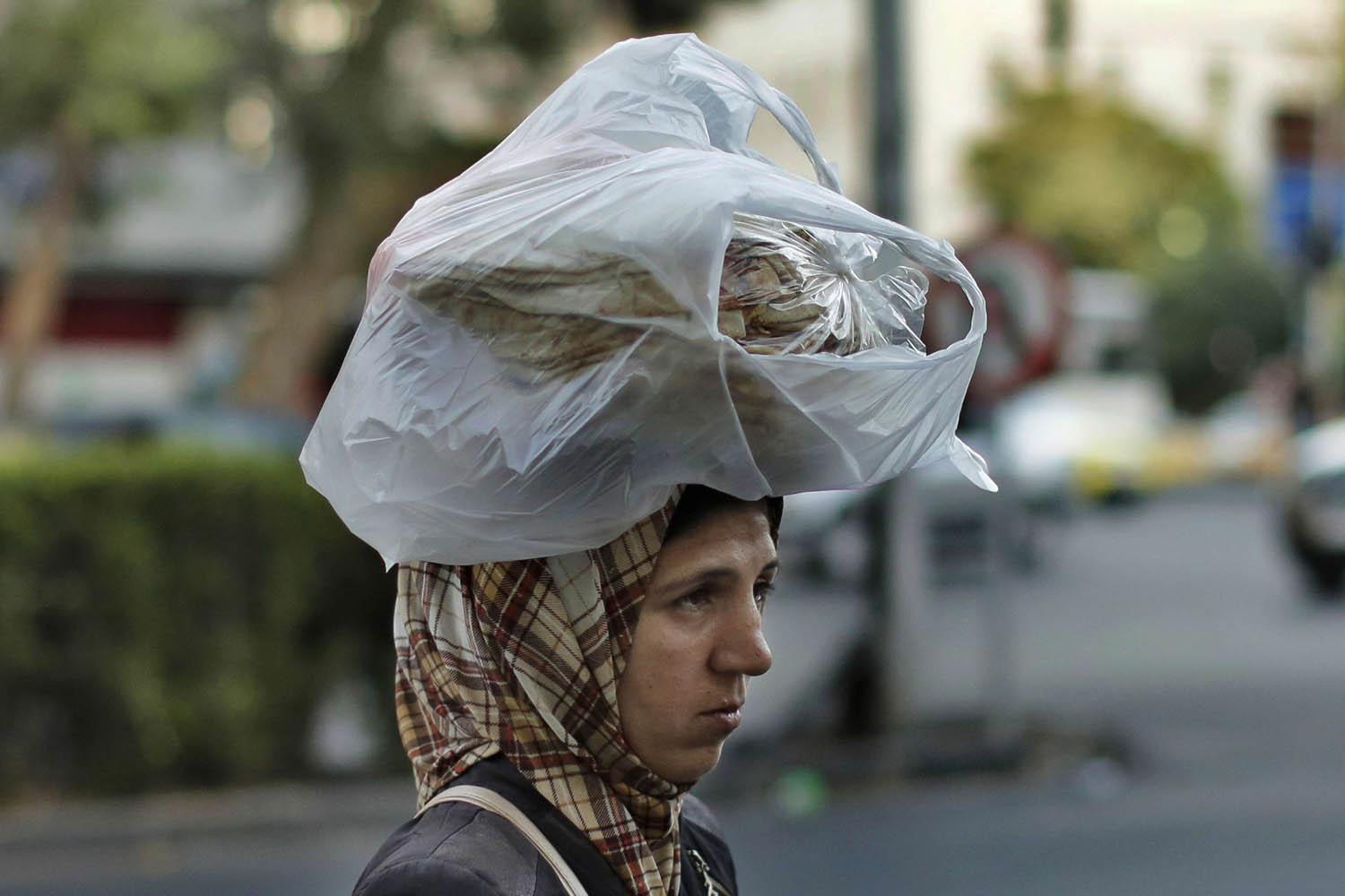 سورية تضع كيسا من الخبز على رأسها وسط دمشق
