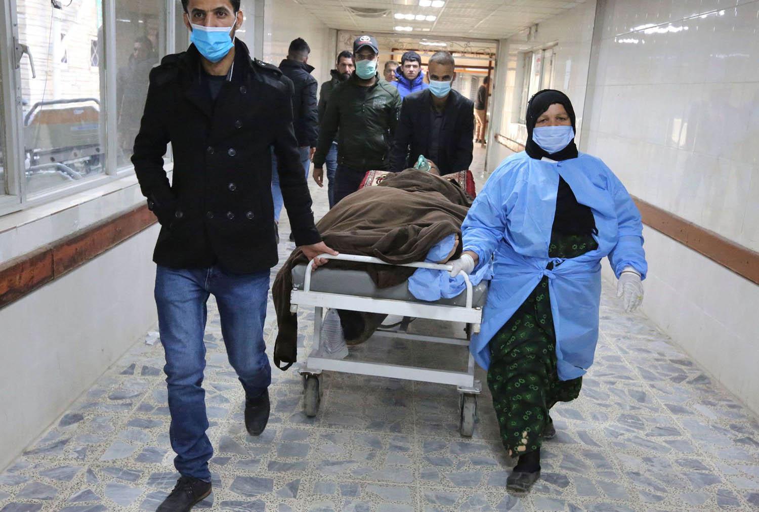 موظفون صحيون ينقلون جرحى انفجار ساحة الطيران في بغداد