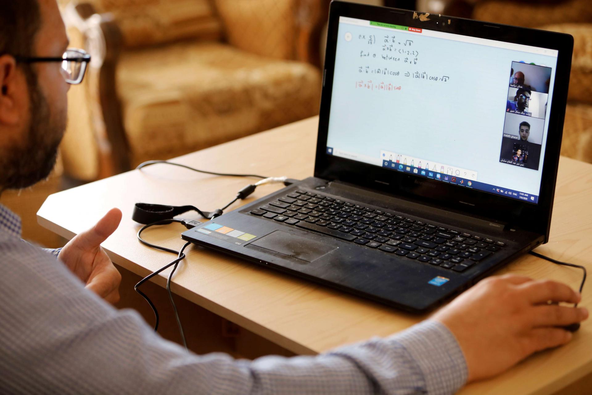 أستاذ مساعد في الرياضيات في جامعة النجاح يلقي محاضرة عبر الإنترنت لطلابه في منزله في طوباس بالضفة الغربية