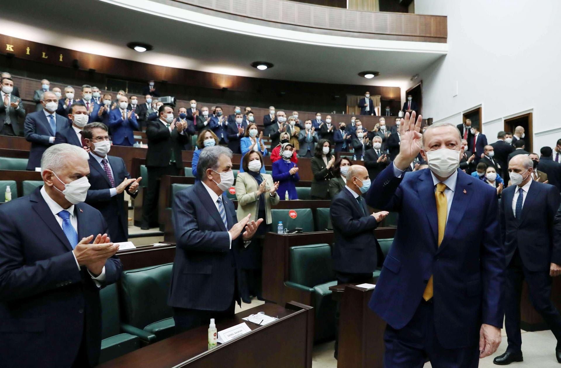 الرئيس التركي رجب طيب إردوغان يحيي أعضاء حزبه خلال اجتماع بالبرلمان