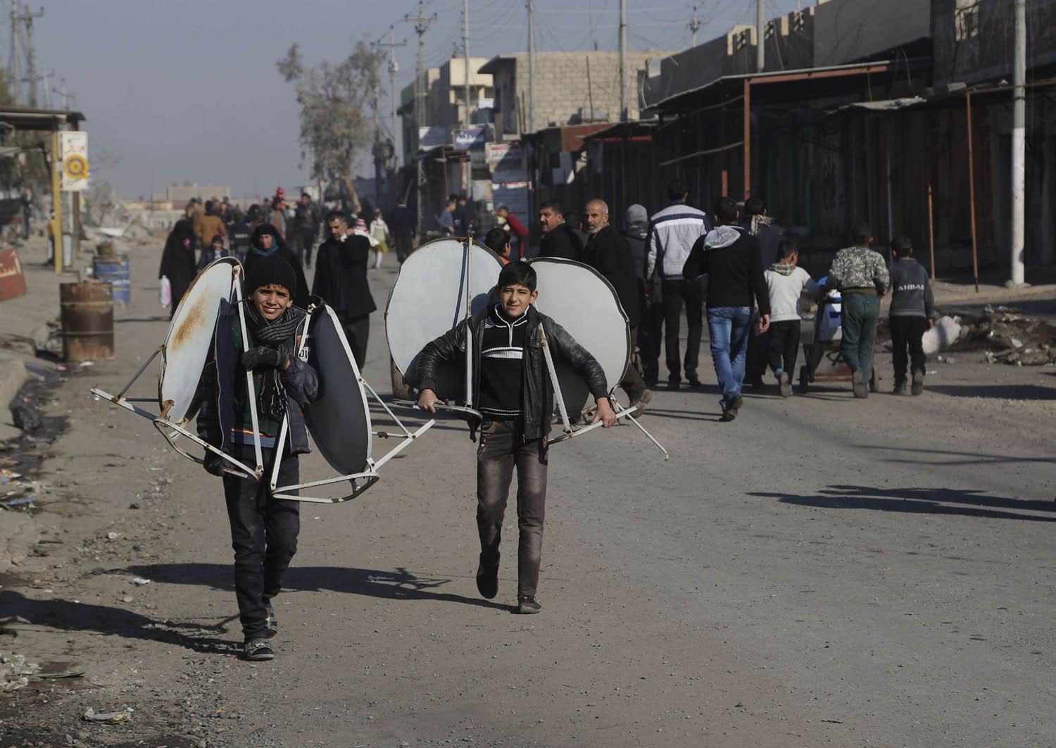 أطفال يحملون صحونا لاقطة في الموصل