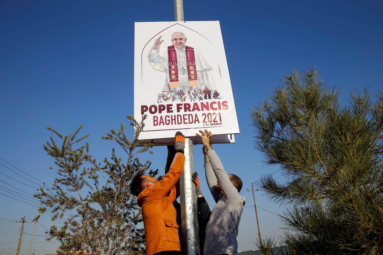 عراقيون في قراقوش يرفعون ملصقات احتفالا بزيارة البابا فرانسيس