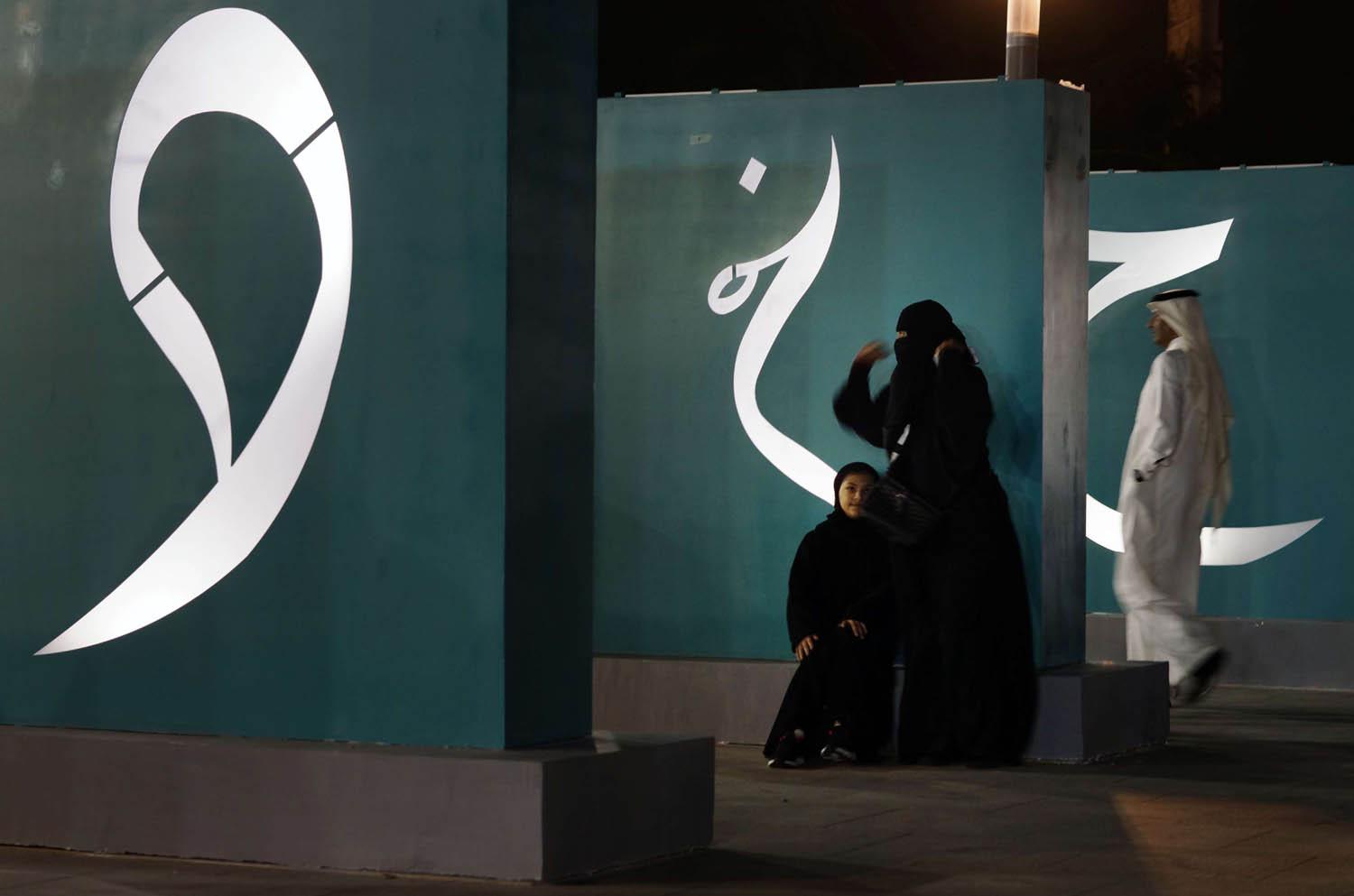 سعوديات يسترحن من جولة في معرض ثقافي في الرياض