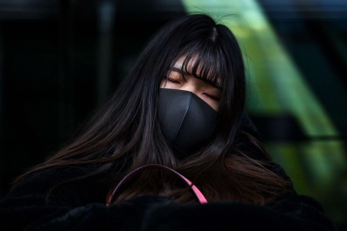 امرأة صينية تنام في محطة قطار