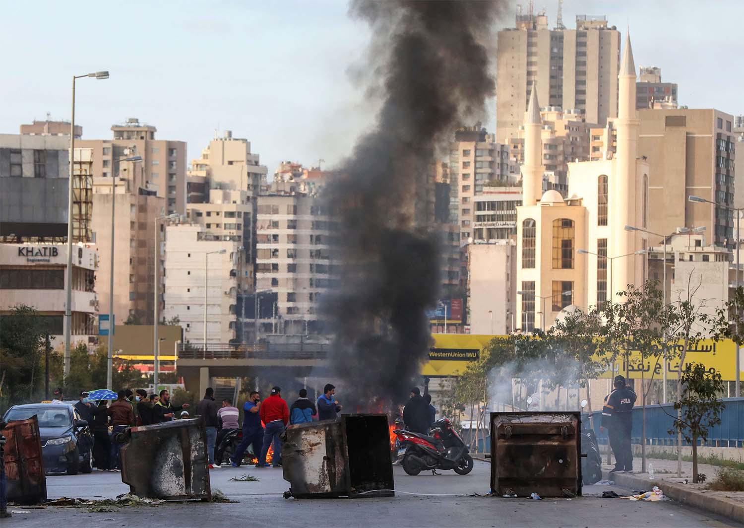Demonstrators block a road in Beirut with garbage bins