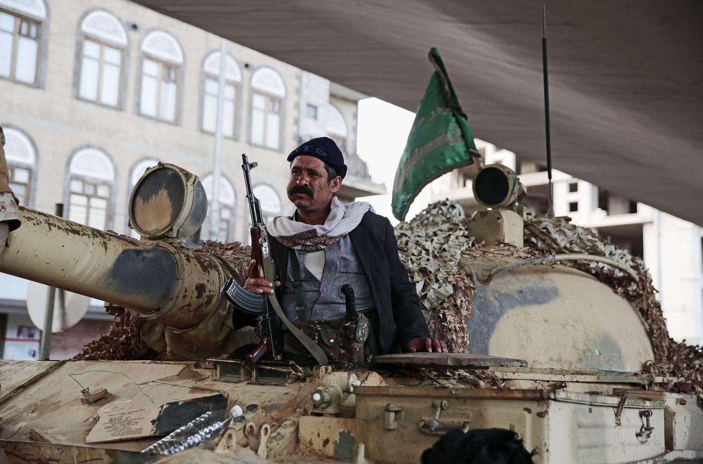 مقاتل حوثي شيعي يقود دبابة