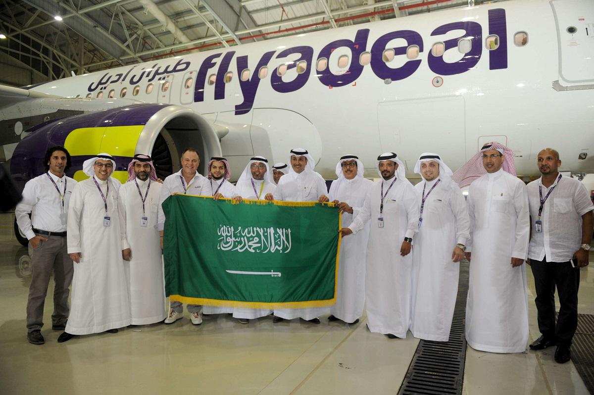 موظفون سعوديون يعرضون العلم الوطني في مطار الملك عبد العزيز في مدينة جدة 